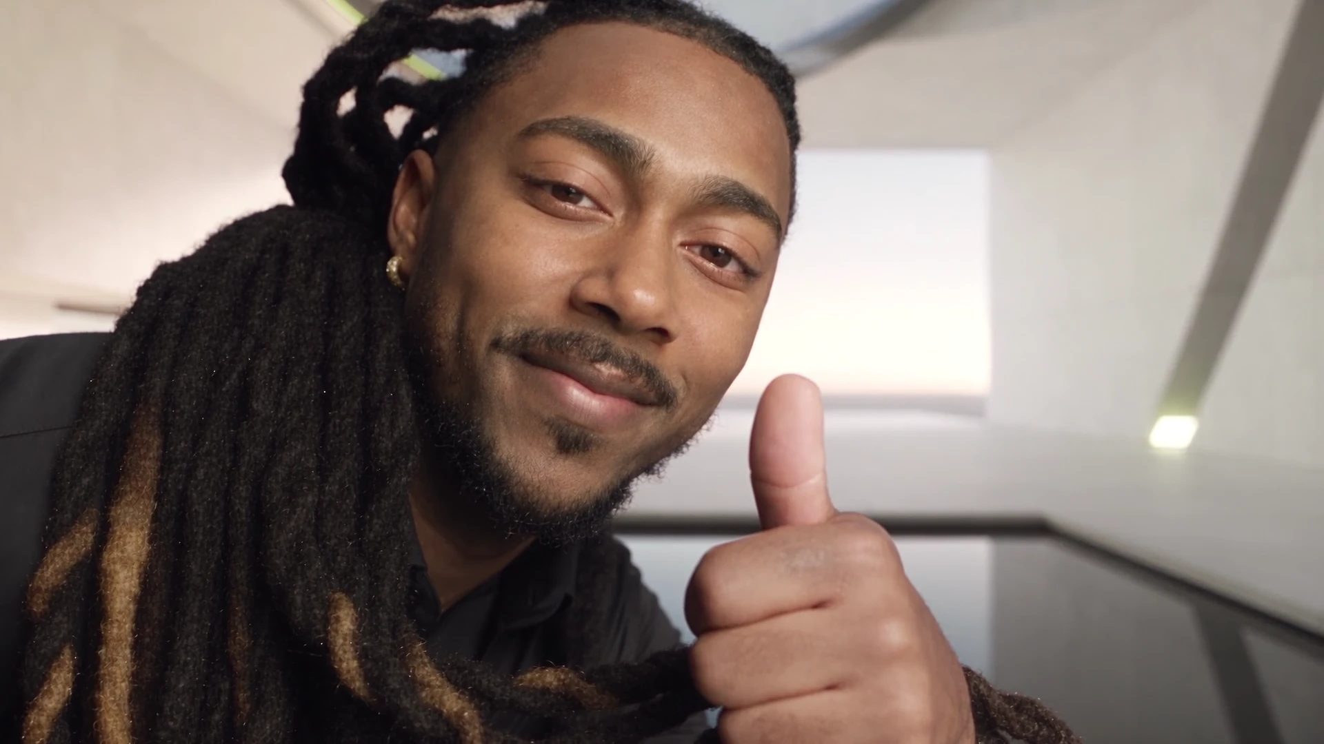 The Prescod Digital founder smiling and giving a thumbs up in a white architectural studio